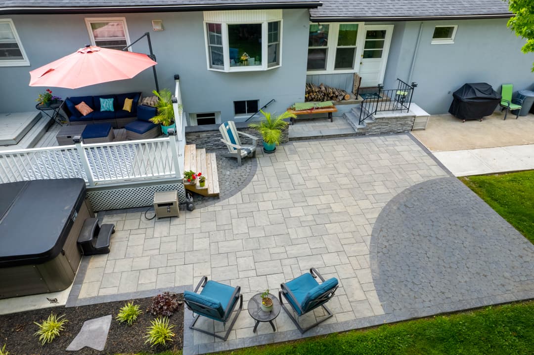 Spacious backyard with patio, outdoor seating, hot tub, and shaded area for relaxation.