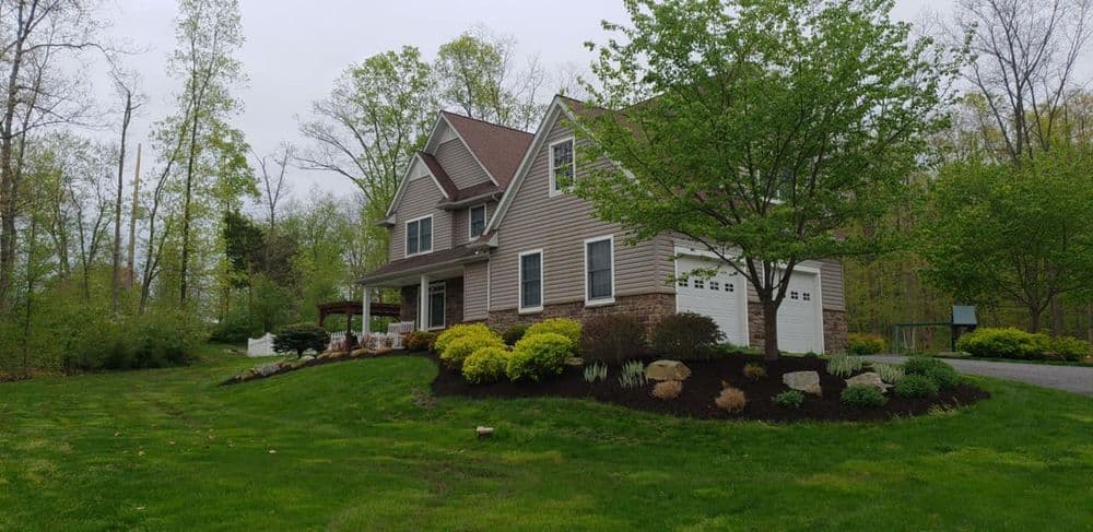 Charming suburban home with landscaped yard and lush greenery in serene forested setting.