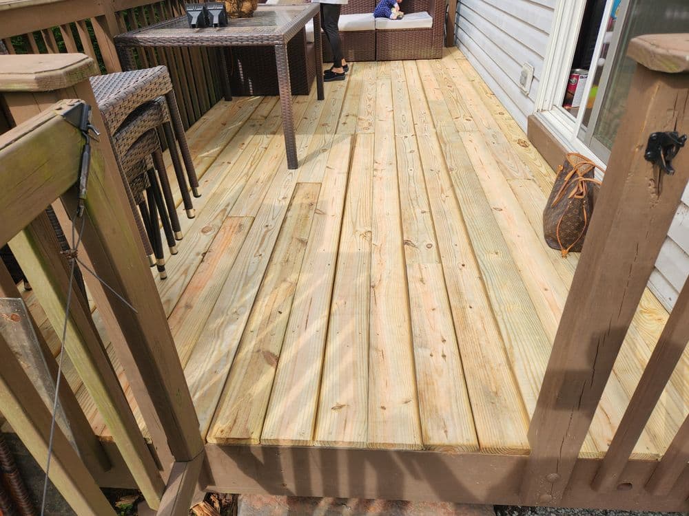 Newly built wooden deck with clean boards and outdoor furniture for relaxation.