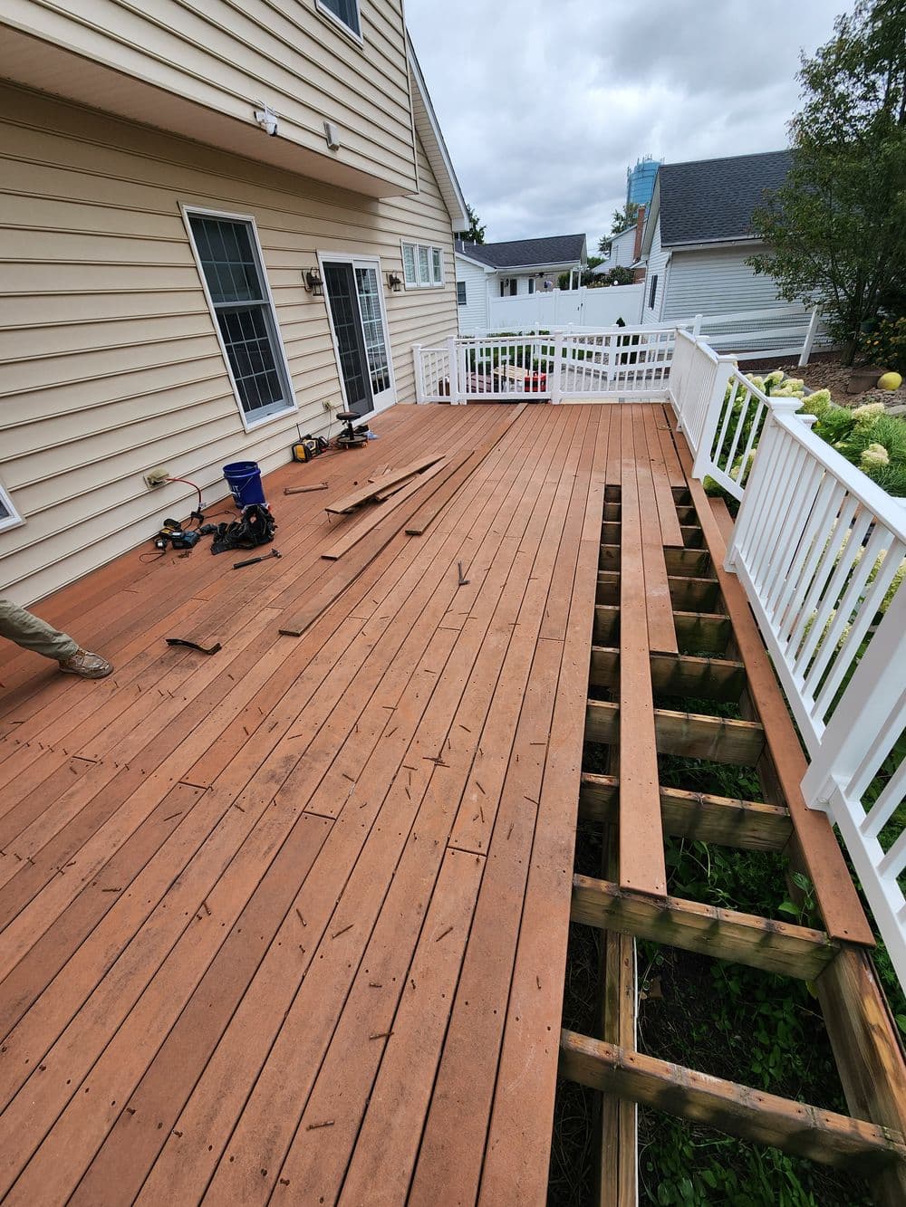 Wooden deck renovation showing partially assembled boards and railings on a residential home.