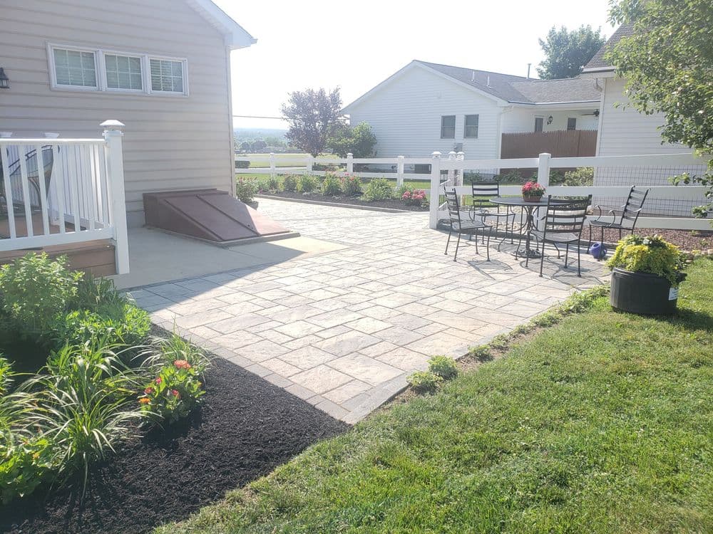Elegant backyard patio with stone pavers, seating area, and landscaped garden. Perfect for gatherings.
