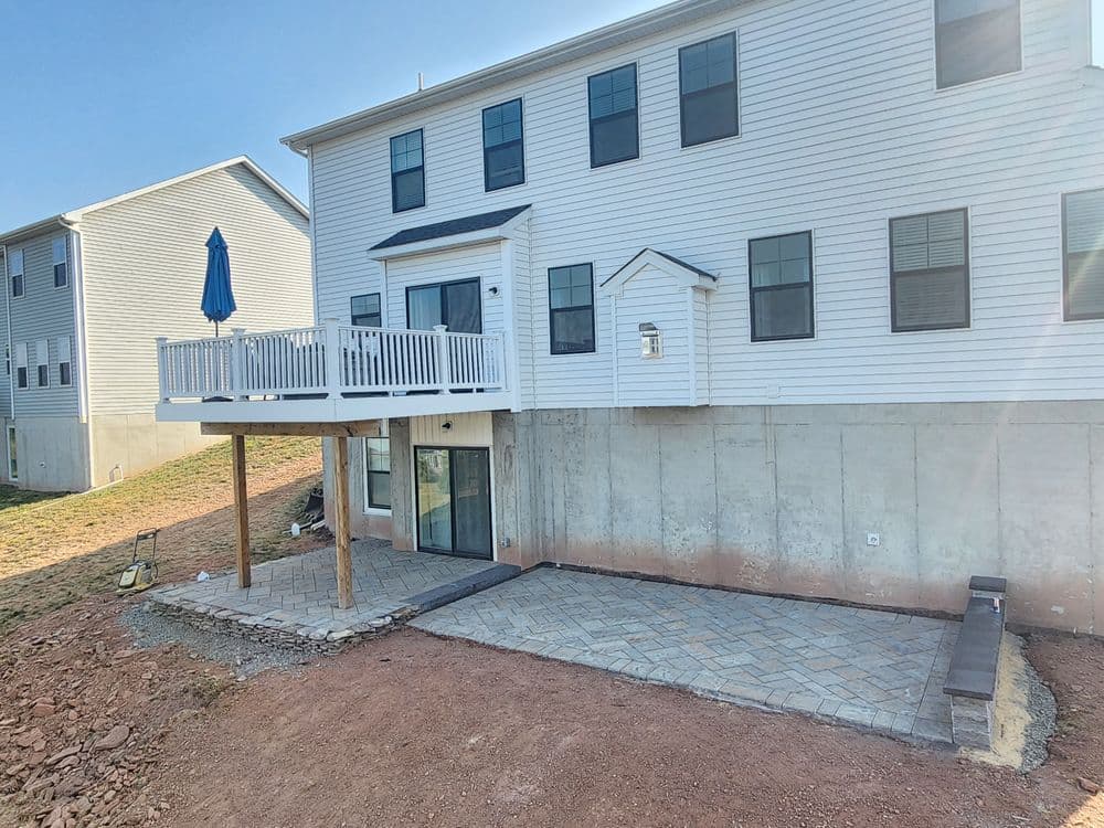 Newly constructed home with a backyard patio and deck on a sunny day.