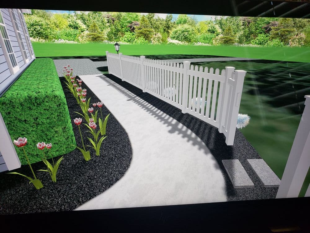 Landscaped walkway with white picket fence, flowers, and greenery in a sunny garden setting.
