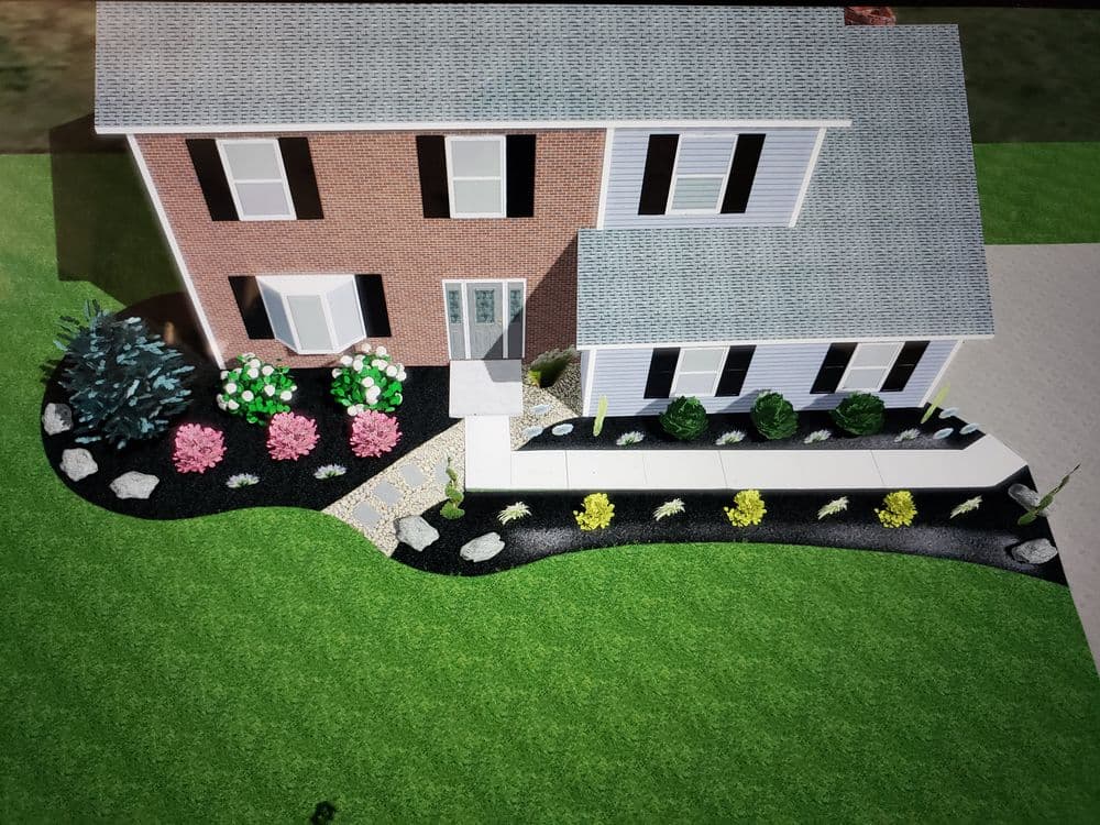 Aerial view of a landscaped home featuring flowers, shrubs, and a curved pathway.