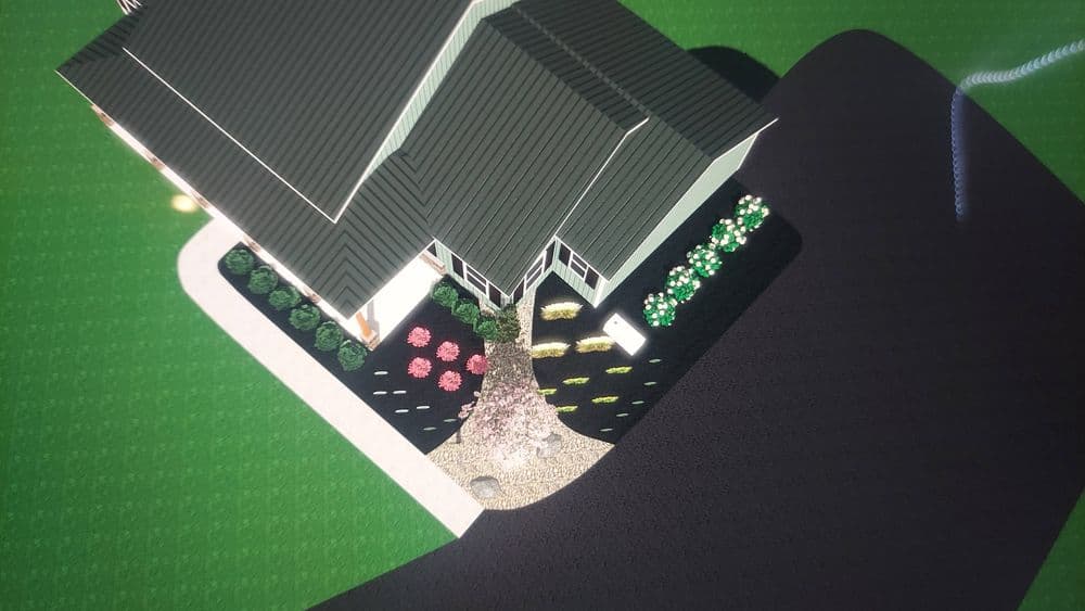 Aerial view of a landscaped home with colorful flower beds and a dark driveway.