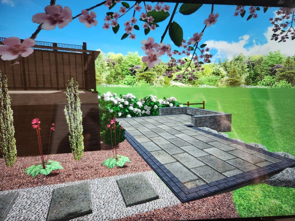 Landscape design featuring a patio, flowering plants, and lush green grass under a bright sky.