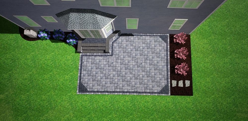 Aerial view of a patio with stone pavers, flowers, and a house exterior. Green lawn surrounding.