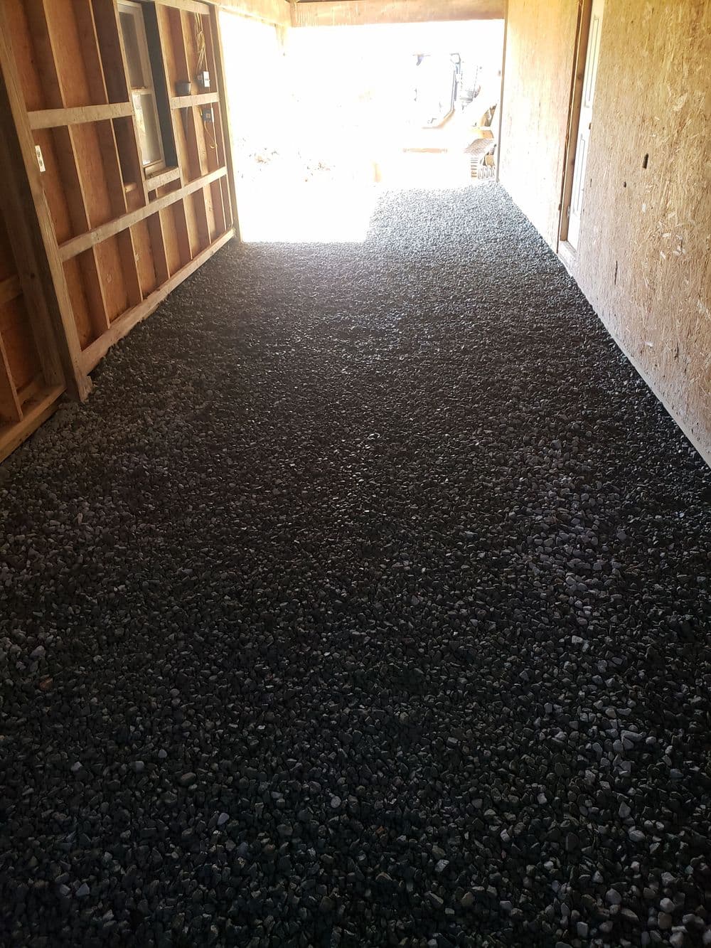 Gravel floor installation in a well-lit indoor space with wooden walls.